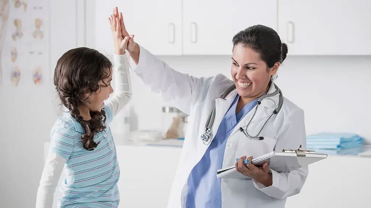 Photo of a doctor high fiving a young patient