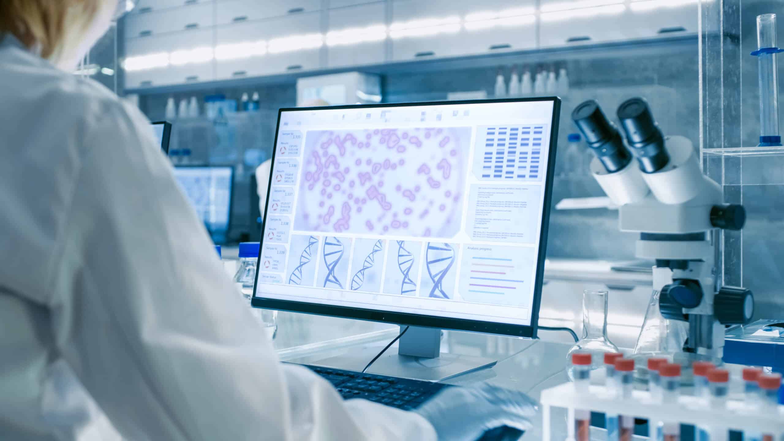 Photo of a person in a lab analyzing results on a screen
